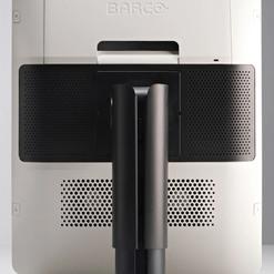 Rückansicht eines Monitors mit Standfuß, an der Wand befestigt, Logo "BARCO" oben sichtbar.