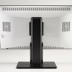 Rückansicht eines modernen Monitors mit schwarzem Standfuß auf einem hellen Tisch.